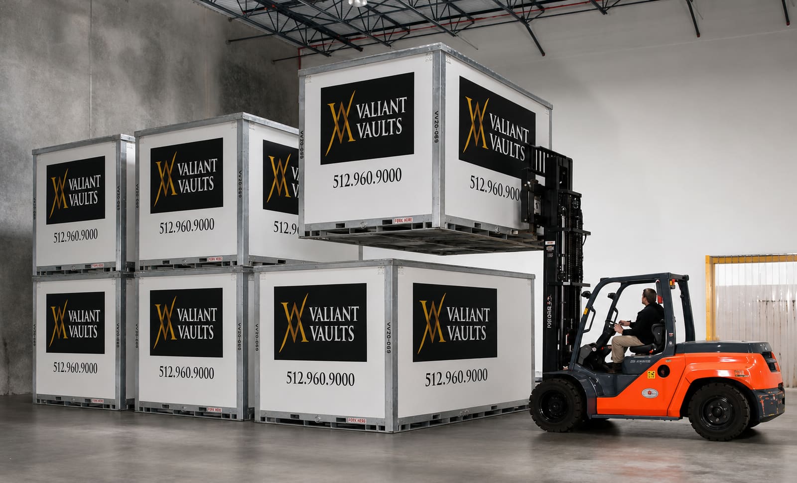 Valiant Vaults forklift moving stacked storage containers inside the secure warehouse facility
